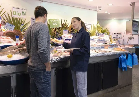 Un client parlant à la personne en charge du rayon poisson